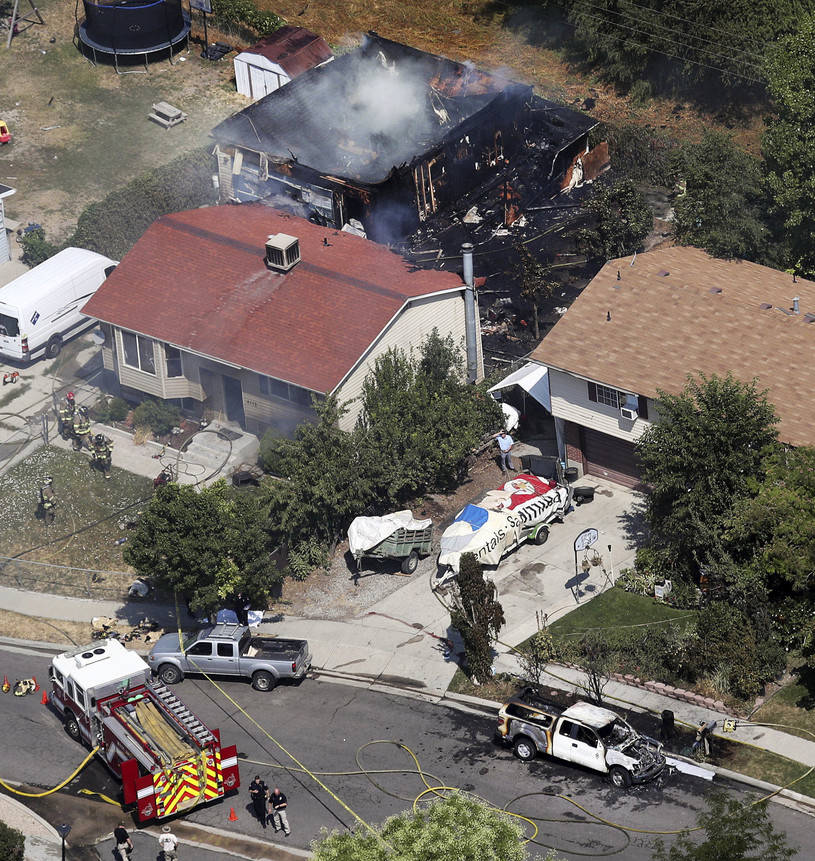 Firefighters work at the scene of a structure fire and fatal shooting in West Valley City, Utah, on Thursday, Aug. 9, 2018. (Ravell Call/The Deseret News via AP)