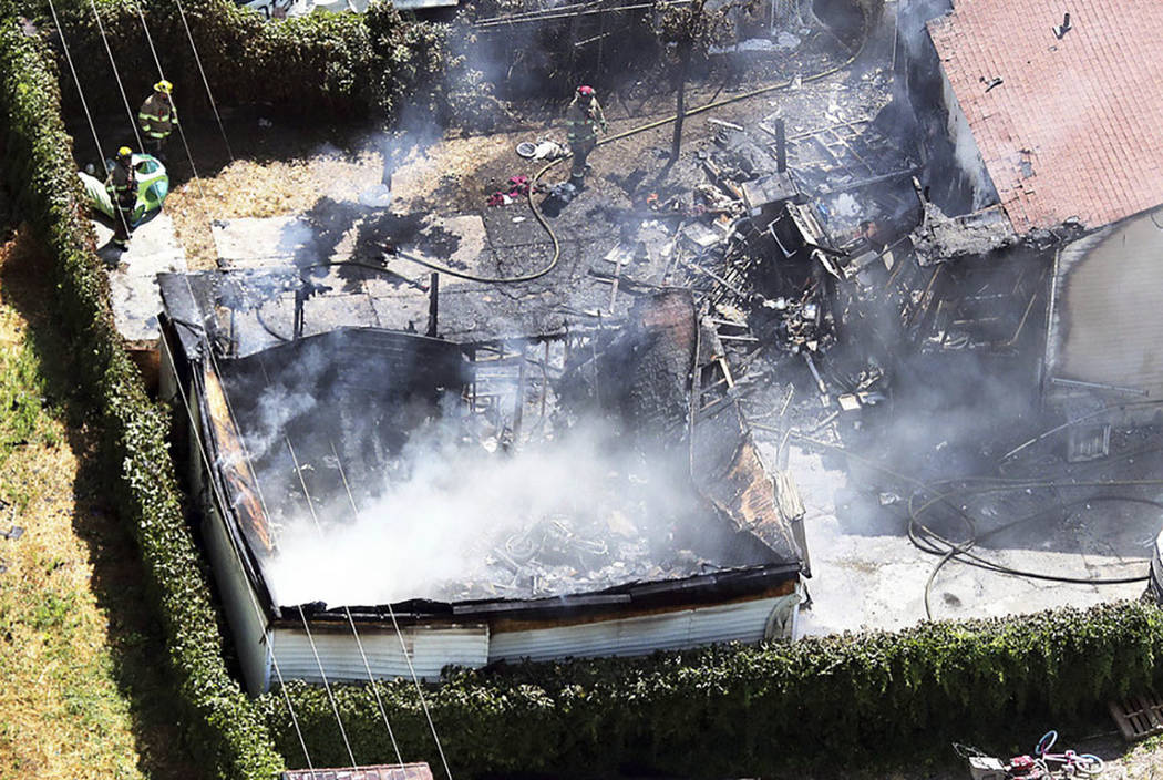 Firefighters work at the scene of a structure fire in West Valley City, Utah, on Thursday, Aug. 9, 2018. A West Valley City code enforcement officer was fatally shot nearby. (Ravell Call/The Des ...