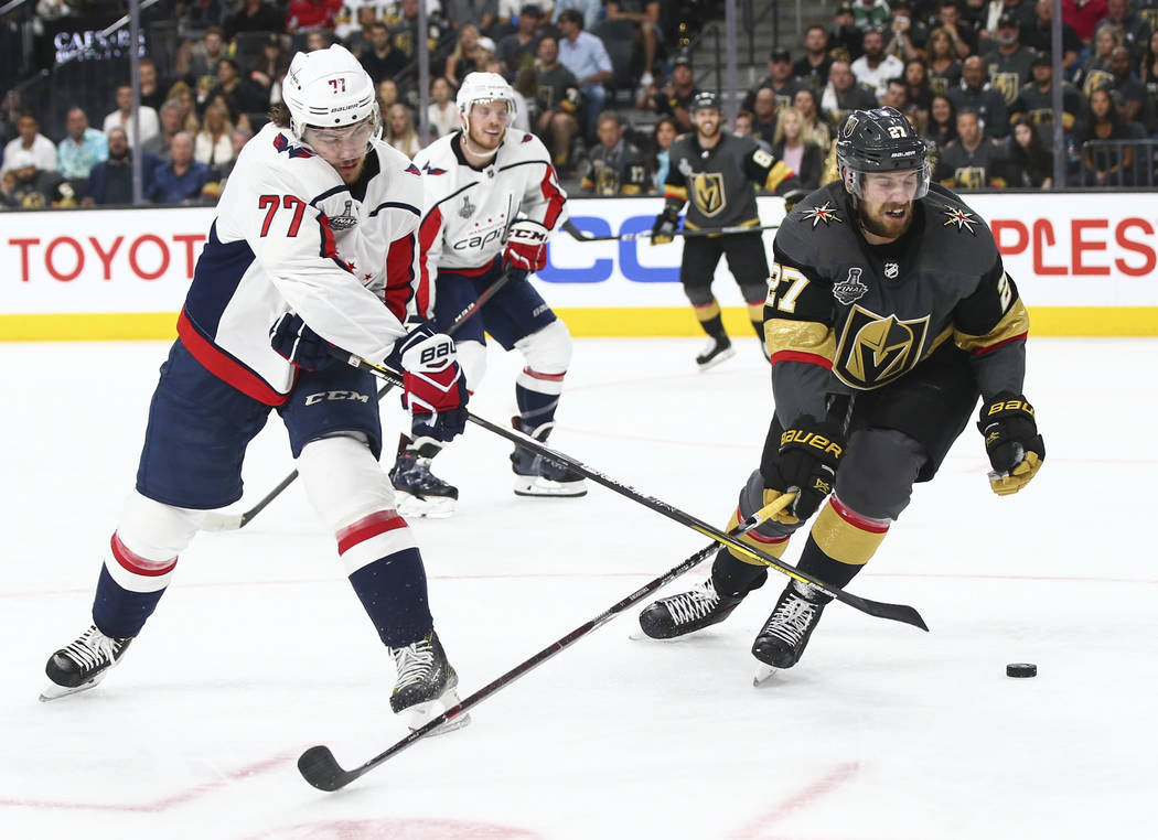 Washington Capitals right wing T.J. Oshie (77) sends the puck past Golden Knights defenseman Shea Theodore (27) during the second period of Game 1 of the NHL hockey Stanley Cup Final at the T-Mobi ...
