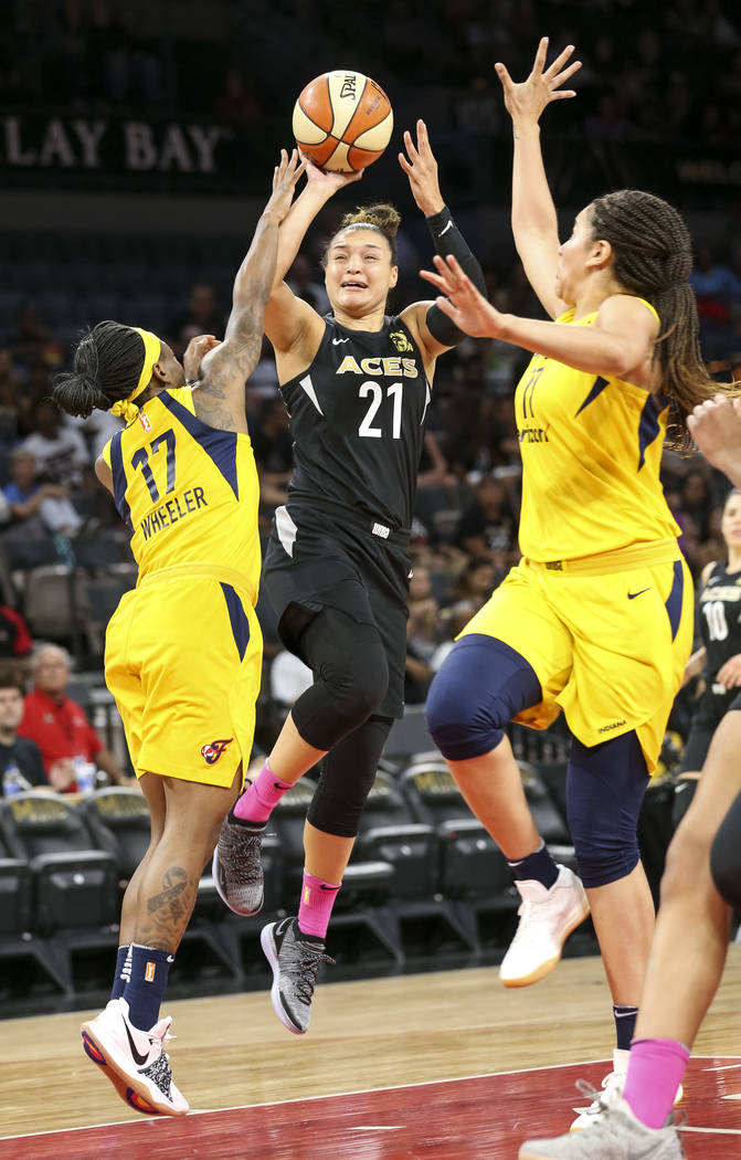Las Vegas Aces guard Kayla McBride (21) takes a shot through Indiana Fever guard Erica Wheeler (17) and Fever forward Natalie Achonwa (11) during the first half of a WNBA basketball game at the Ma ...