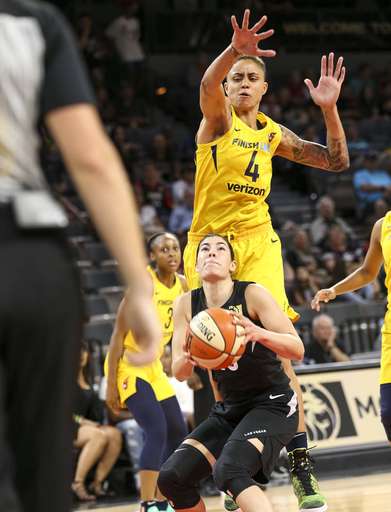 Las Vegas Aces guard Kelsey Plum (10) looks for shot as Indiana Fever forward Candice Dupree (4) goes in for the block during the second half of a WNBA basketball game at the Mandalay Bay Events C ...