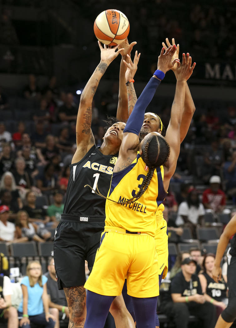 Las Vegas Aces forward Tamera Young (1), Indiana Fever guard Tiffany Mitchell (3) and Fever center Kayla Alexander (40) vie for the ball during the first half of a WNBA basketball game at the Mand ...