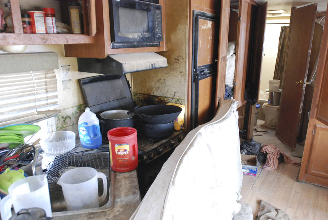 Various items litter the kitchen of a makeshift living compound in Amalia, N.M., on Friday, Aug. 10, 2018, where five adults were arrested on child abuse charges and remains of a boy were found. T ...