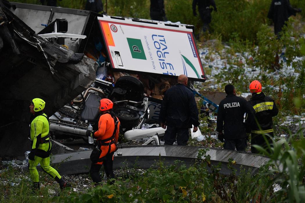 Rescues work among the debris of the collapsed Morandi highway bridge in Genoa, Tuesday, Aug. 14, 2018. Italian authorities say that about 10 vehicles were involved when the raised highway collaps ...