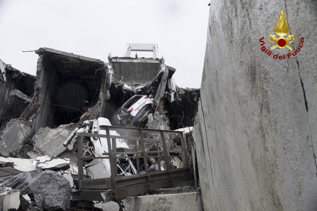 This photo released by the Italian firefighters, cars are seen among the rubble of the collapsed Morandi highway bridge in Genoa, northern Italy, Tuesday, Aug. 14, 2018. A large section of the bri ...