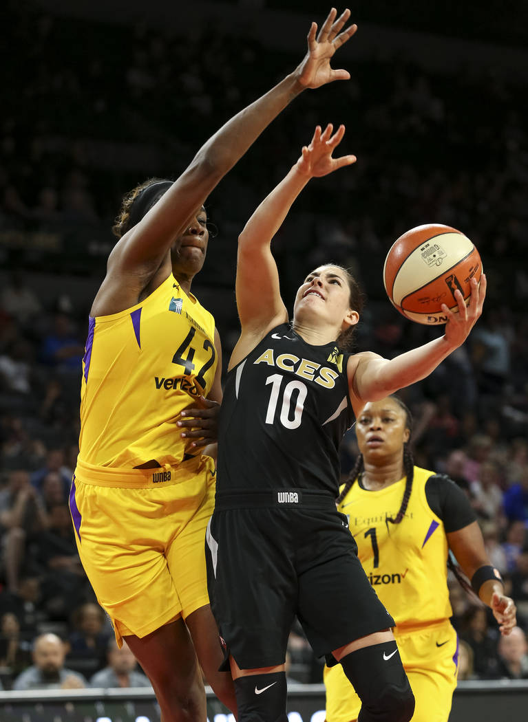 Las Vegas Aces guard Kelsey Plum (10) gets fouled by Los Angeles Sparks center Jantel Lavender (42) as she goes for a shot in the first half of a WNBA basketball game at the Mandalay Bay Events Ce ...
