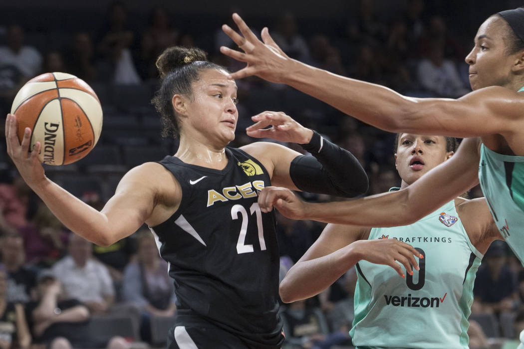 Aces guard Kayla McBride (21) makes a baseline pass around New York Liberty defenders Marissa Coleman (0) and Kiah Stokes (41) in the fourth quarter on Wednesday, Aug. 15, 2018, at the Mandalay Ba ...