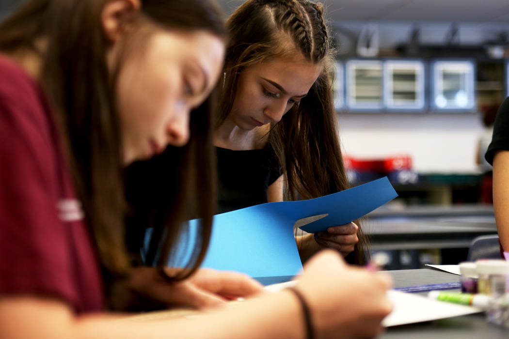Autumn Berner, 15, left, and Abbey Mashore, 15, create social media logos on paper for the bulletin board at school to get the word out about their robotics team at Las Vegas Academy in Las Vegas, ...