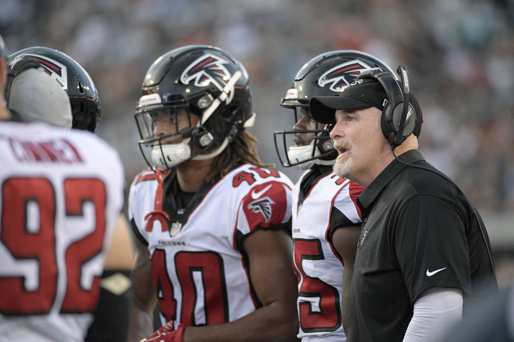 Atlanta Falcons head coach Dan Quinn, right, talks to his players on the sideline during the first half of an NFL preseason football game against the Jacksonville Jaguars Saturday, Aug. 25, 2018, ...