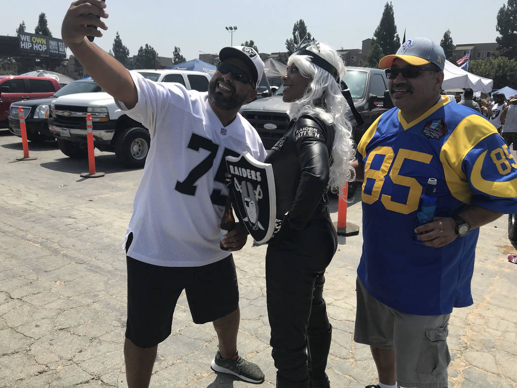 Faith Turner, center, who goes by Raider Storm, accepts photo request from football fans before Raiders-Rams game in Los Angeles. (Gilbert Manzano)