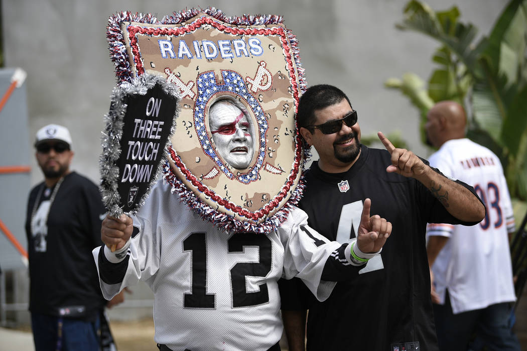 Oakland Raider fans pose before an NFL preseason football game against the Los Angeles Rams Saturday, Aug. 18, 2018, in Los Angeles. (AP Photo/Kelvin Kuo)