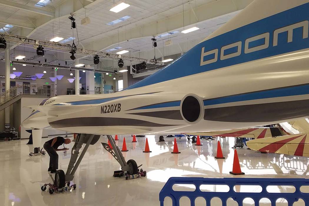 An attendee of a reception by Boom Supersonic at Centennial Airport in Englewood, Colorado, has a look under the fuselage of a model of the company's XB-1 test jet on Saturday, Aug. 18, 2018. Rich ...