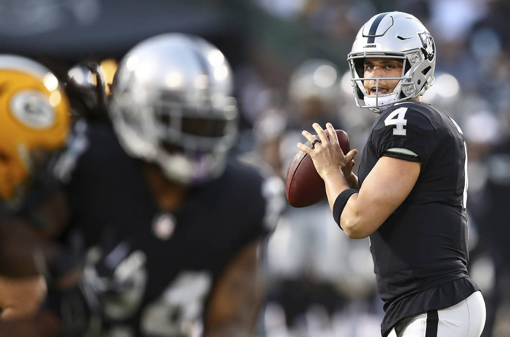 Oakland Raiders quarterback Derek Carr (4) looks for a receiver during the first half of the team's NFL preseason football game against the Green Bay Packers in Oakland, Calif., Friday, Aug. 24, 2 ...