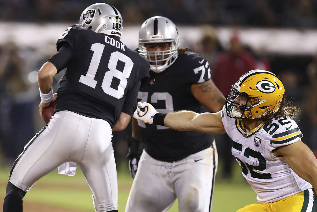 Green Bay Packers linebacker Clay Matthews (52) applies pressure to Oakland Raiders quarterback Connor Cook (18) during the first half of an NFL preseason football game in Oakland, Calif., Friday, ...