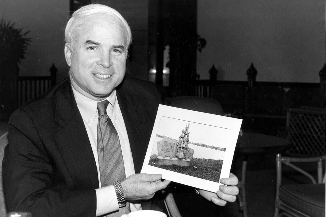 U.S. Rep. John McCain III, R-Ariz., holds a photo of a marker in Hanoi at Truc Bach Lake where he parachuted after being shot down as a Navy pilot in the Vietnam War. McCain, who was a POW for fi ...