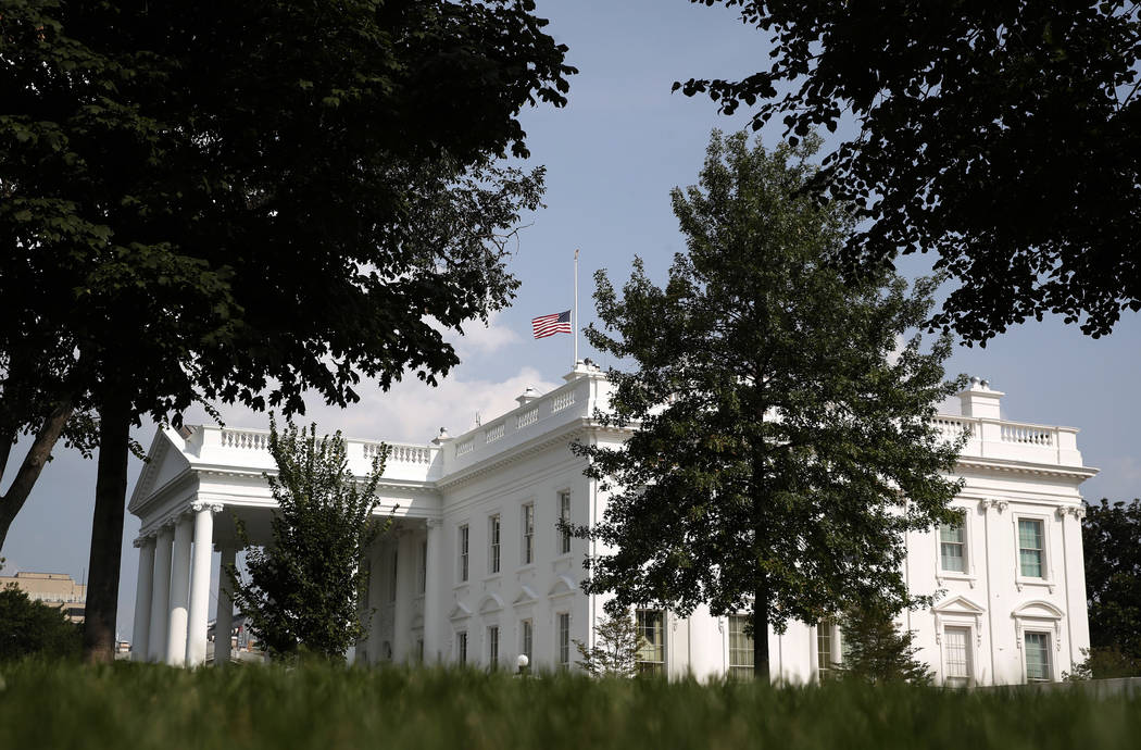 The American flag files at half-staff at the White House, Monday afternoon, Aug. 27, 2018, in Washington. Two days after Sen. John McCain's death, President Donald Trump says he respects the senat ...