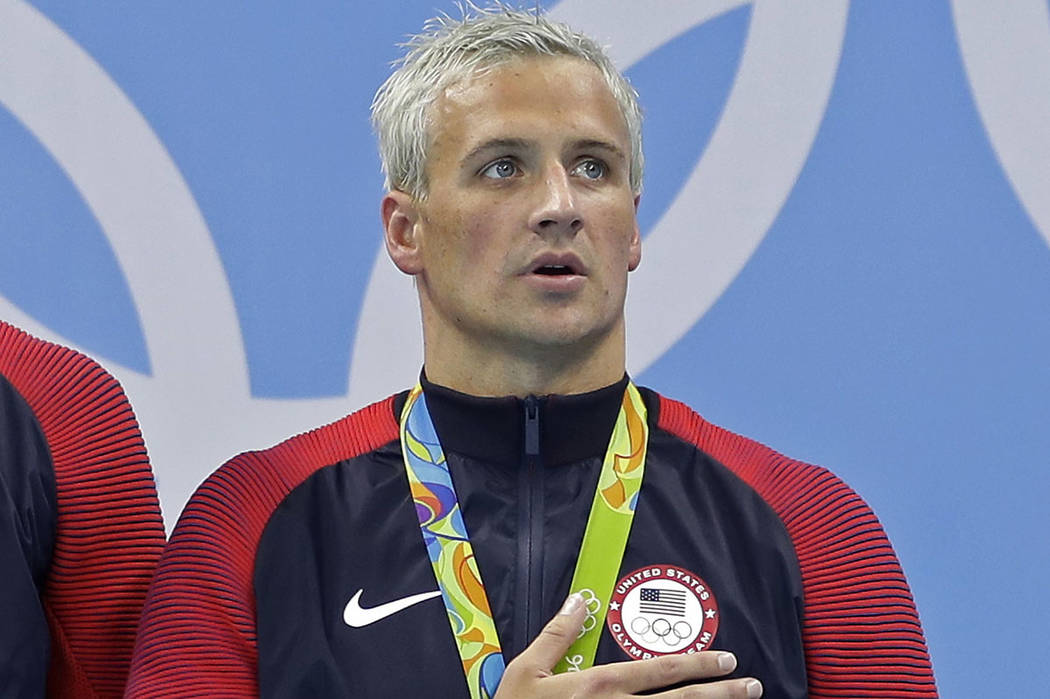 Ryan Lochte listens to the national anthem after being awarded a gold medal during the ceremony for the men's 4x200-meter freestyle relay final at the 2016 Summer Olympics in Rio de Janeiro, Aug. ...