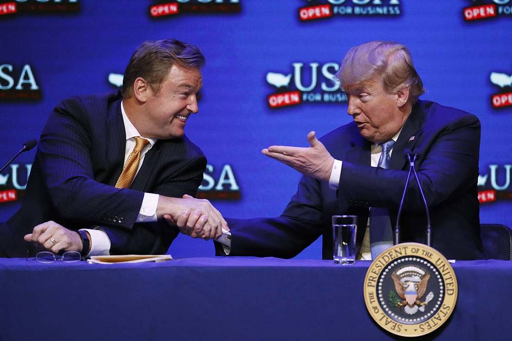 President Donald Trump, right, shakes hands with Sen. Dean Heller, R-Nev., during a roundtable discussion on tax reform Saturday, June 23, 2018, in Las Vegas. (AP Photo/John Locher)