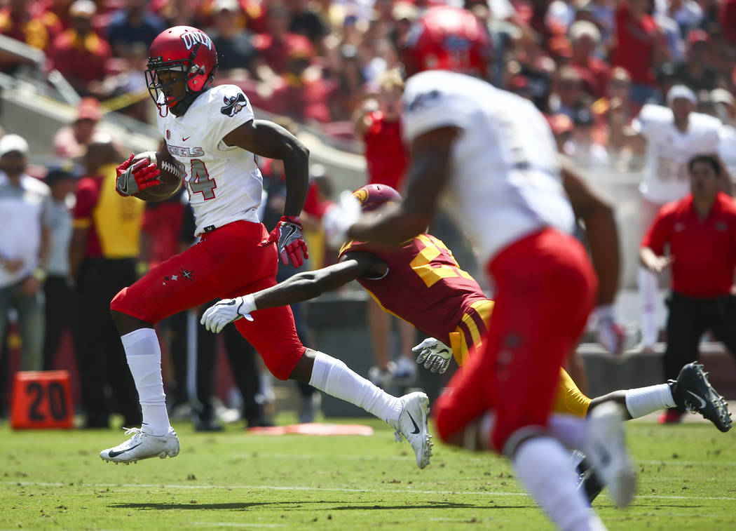 UNLV Rebels wide receiver Kendal Keys (84) avoids a tackle from USC Trojans cornerback Ajene Harris (27) on his way to score a touchdown during the first half of a football game at the Los Angeles ...
