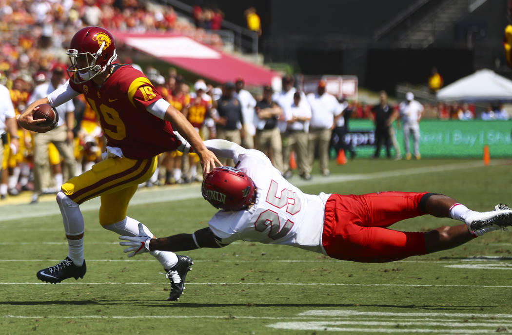 UNLV Rebels linebacker Gabe McCoy (25) attempts to take down USC Trojans quarterback Matt Fink (19) during the first half of a football game at the Los Angeles Memorial Coliseum in Los Angeles on ...
