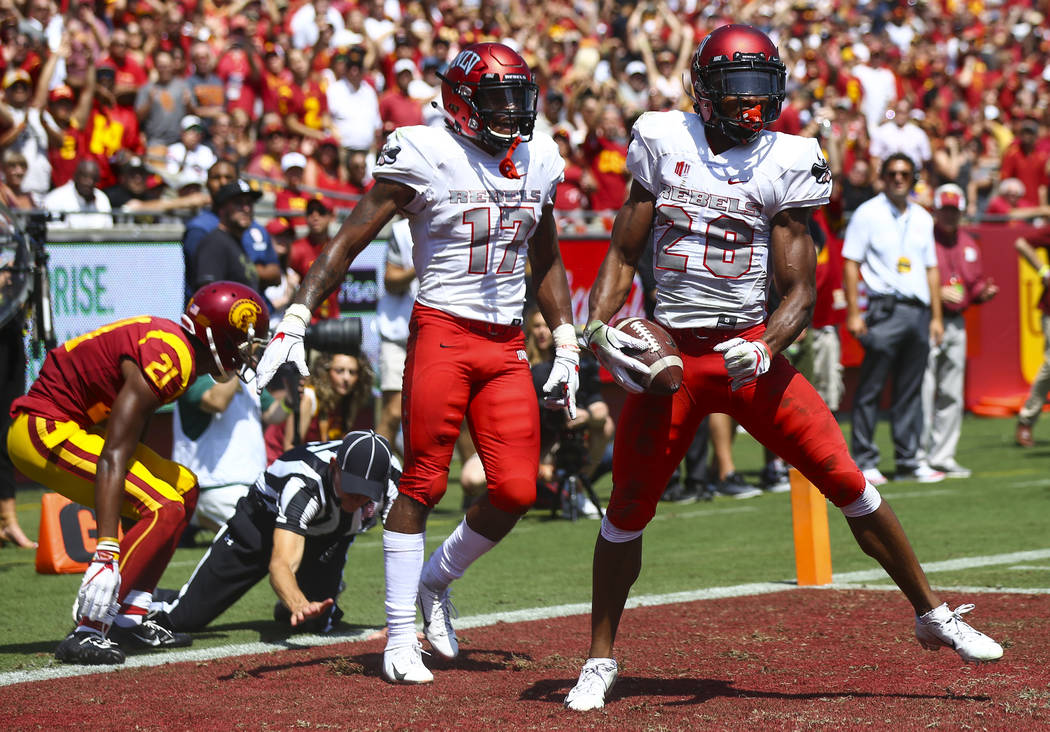 UNLV Rebels defensive back Jocquez Kalili (26) reacts after taking down USC Trojans wide receiver Tyler Vaughns (21) as UNLV Rebels defensive back Evan Austrie (17) looks on during the first half ...