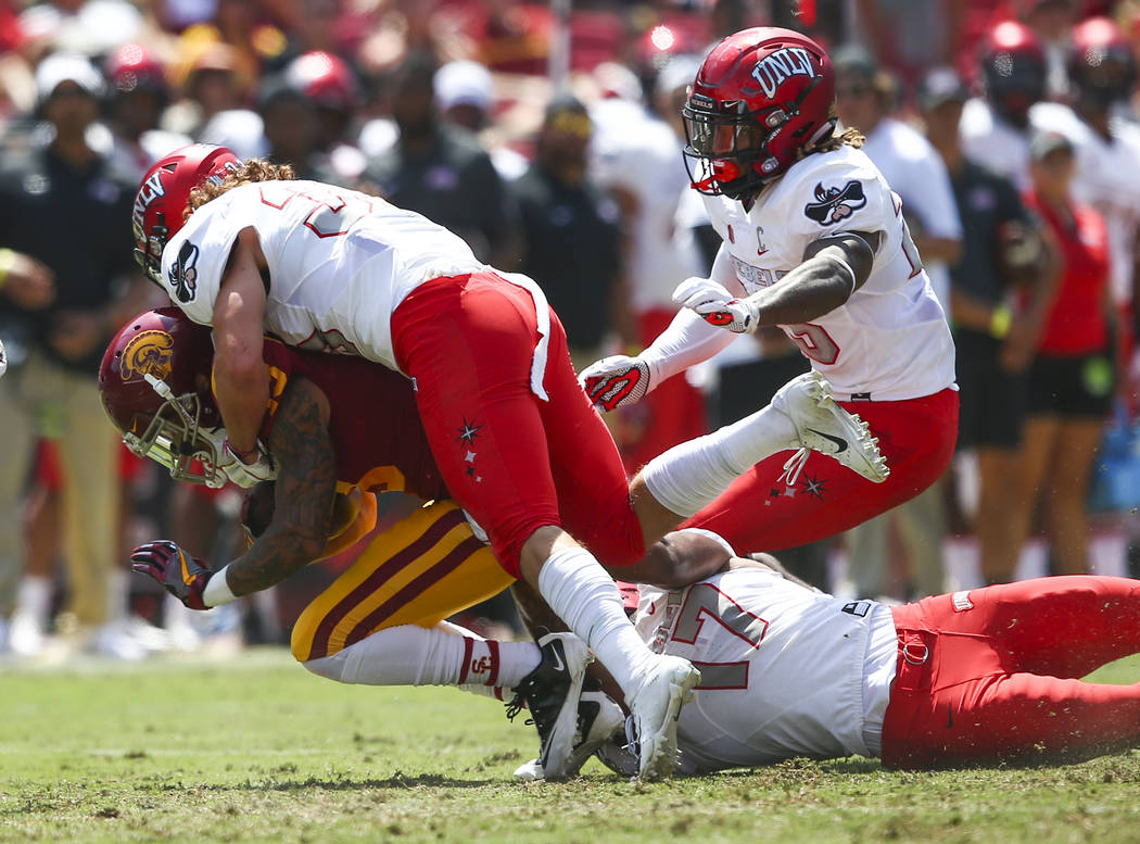 UNLV Rebels defensive back Dalton Baker (33) tackles USC Trojans wide receiver Trevon Sidney (13) during the first half of a football game at the Los Angeles Memorial Coliseum in Los Angeles on Sa ...