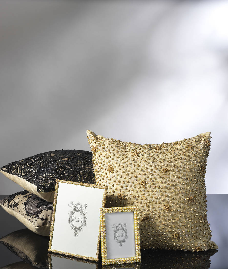 These chic haute couture pillows from Olivia Riegel feature hand-embellishment by master artisans with hundreds of hand-stitched beads, ribbon rosettes and Austrian crystals. (Olivia Riegel)