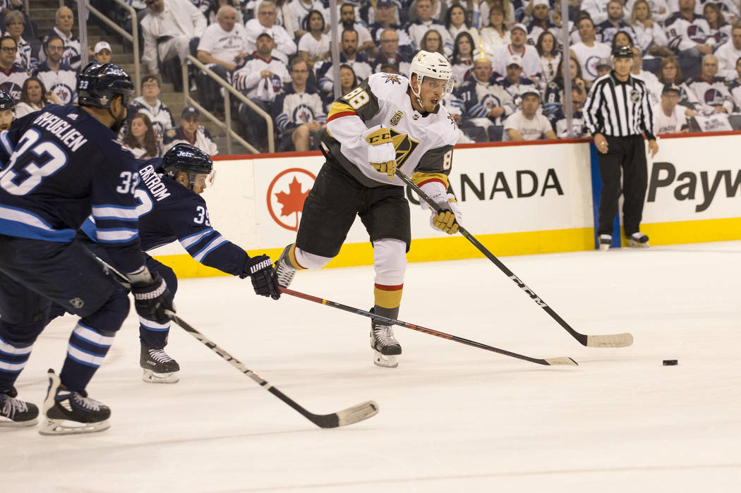 Vegas Golden Knights defenseman Nate Schmidt (88) is pressured by Winnipeg Jets defenseman Toby Enstrom (39) during the first period in Game 1 of an NHL hockey third-round playoff series at the Be ...