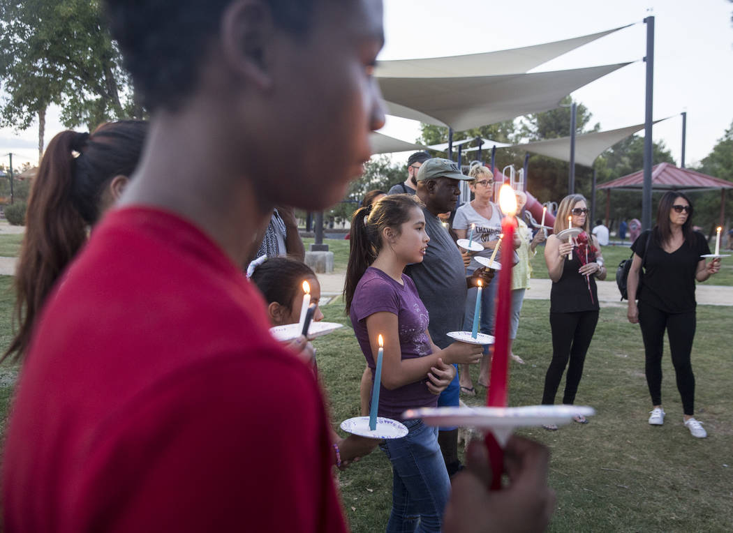 Ares Mendiola, middle, 11, holds a candle during a vigil for Levi Echenique, Daniel Theriot and Dejah Hunt at Sunset Park on Tuesday, Sept. 4, 2018, in Las Vegas. Benjamin Hager Las Vegas Review-J ...