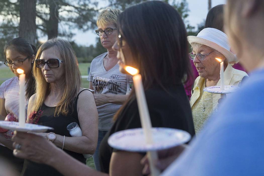 Carrol Carter, right, leads a prayer during a vigil for Levi Echenique, Daniel Theriot and Dejah Hunt at Sunset Park on Tuesday, Sept. 4, 2018, in Las Vegas. (Benjamin Hager/Las Vegas Review-Journ ...