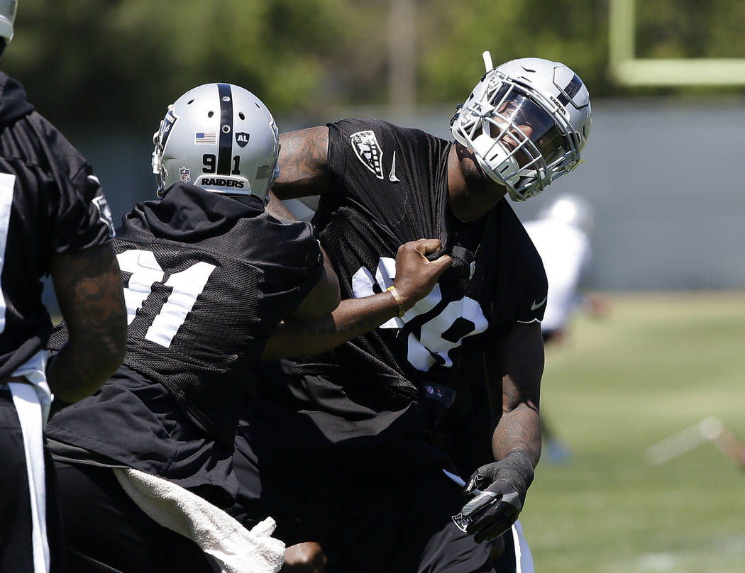 Oakland Raiders linebacker Shilique Calhoun, left, and rookie defensive end Arden Key, right, work on a drill at the NFL football team's minicamp Tuesday, June 12, 2018, in Alameda, Calif. (AP Pho ...