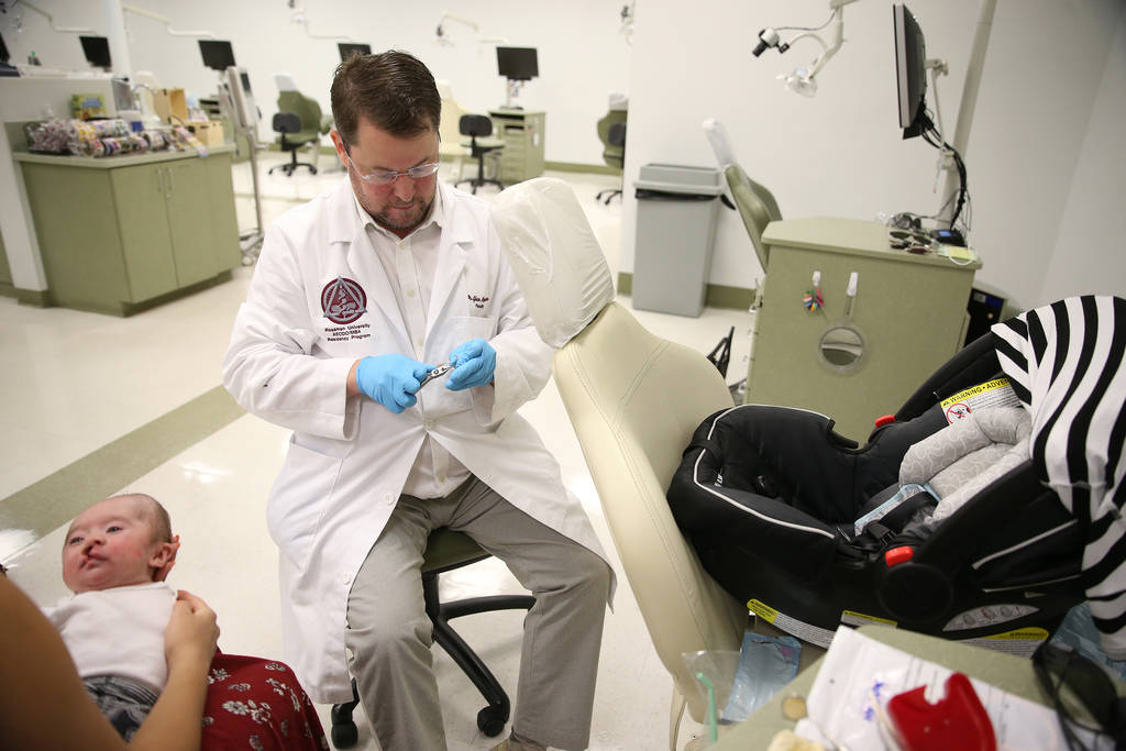 Dr. Glen Roberson, center, an orthodontist at the Orthodontic Clinic at Roseman University, adjust the nasoalveolar molding (NAM) appliance of Blake Muschong, a 10-week-old baby with a cleft palat ...