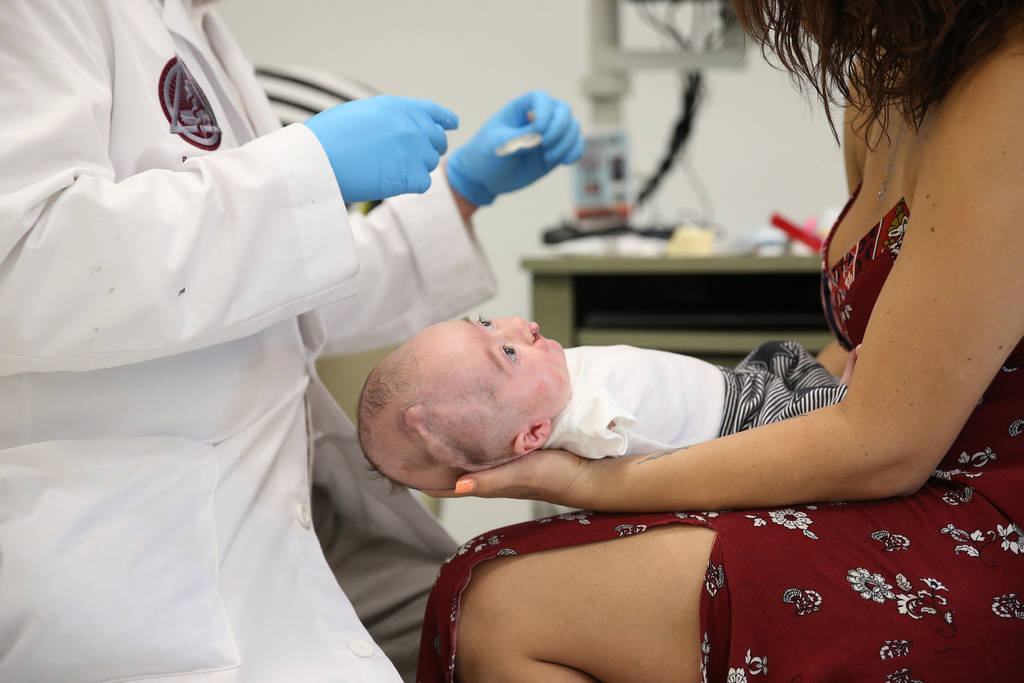 Dr. Glen Roberson, left, an orthodontist at the Orthodontic Clinic at Roseman University, checks the mouth of Blake Muschong, a 10-week-old baby who used the nasoalveolar molding (NAM) appliance, ...
