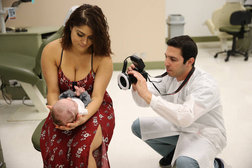 Daniel Khorshad, a third year orthodontist resident, documents progress in the mouth of Blake Muschong, a 10-week-old baby with a cleft palate, during his appointment with his mother Ariale Waibel ...