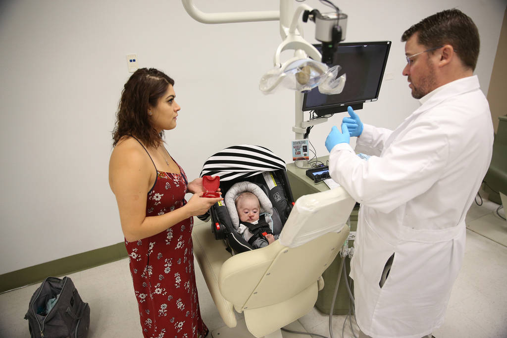 Dr. Glen Roberson, right, an orthodontist at the Orthodontic Clinic at Roseman University, speaks to Ariale Waibel, mother of Blake Muschong, a 10-week-old baby with a cleft palate, during his app ...