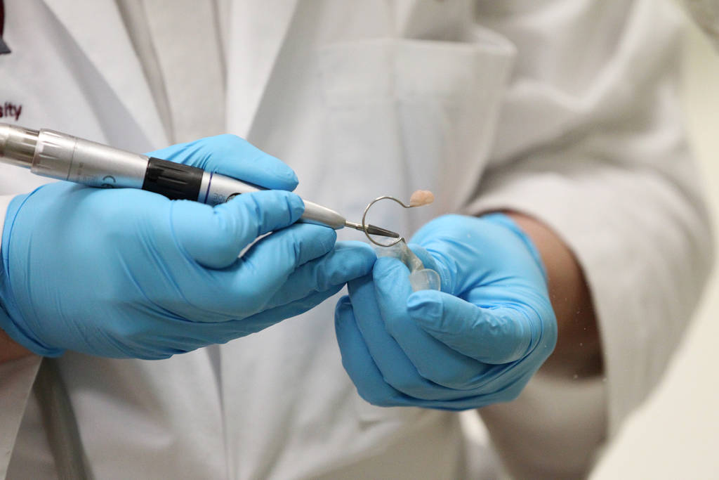 Dr. Glen Roberson, an orthodontist at the Orthodontic Clinic at Roseman University, adjusts the nasoalveolar molding (NAM) of Blake Muschong, a 10-week-old baby with a cleft palate, not pictured, ...