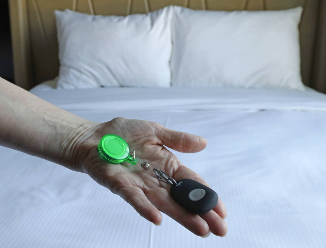 Rani Accettola, a housekeeper at the Embassy Suites by Hilton hotel in Seattle's Pioneer Square neighborhood, poses for a photo while holding a device that lets her push a button and summon help i ...