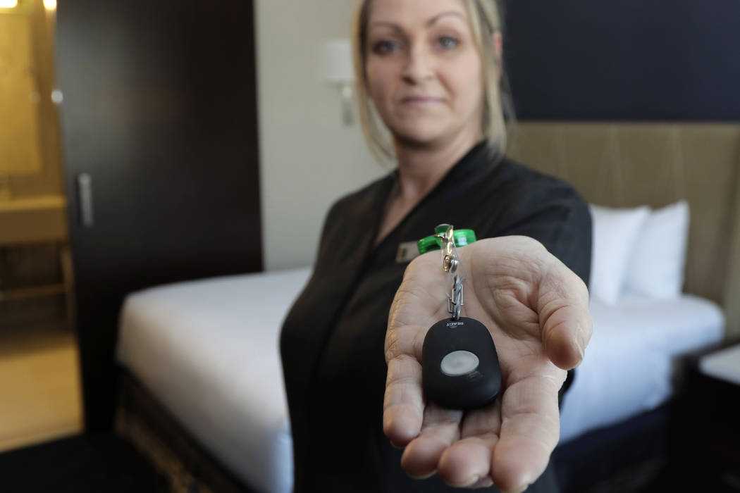 Rani Accettola, a housekeeper at the Embassy Suites by Hilton hotel in Seattle's Pioneer Square neighborhood, poses for a photo while holding a device that lets her push a button and summon help i ...