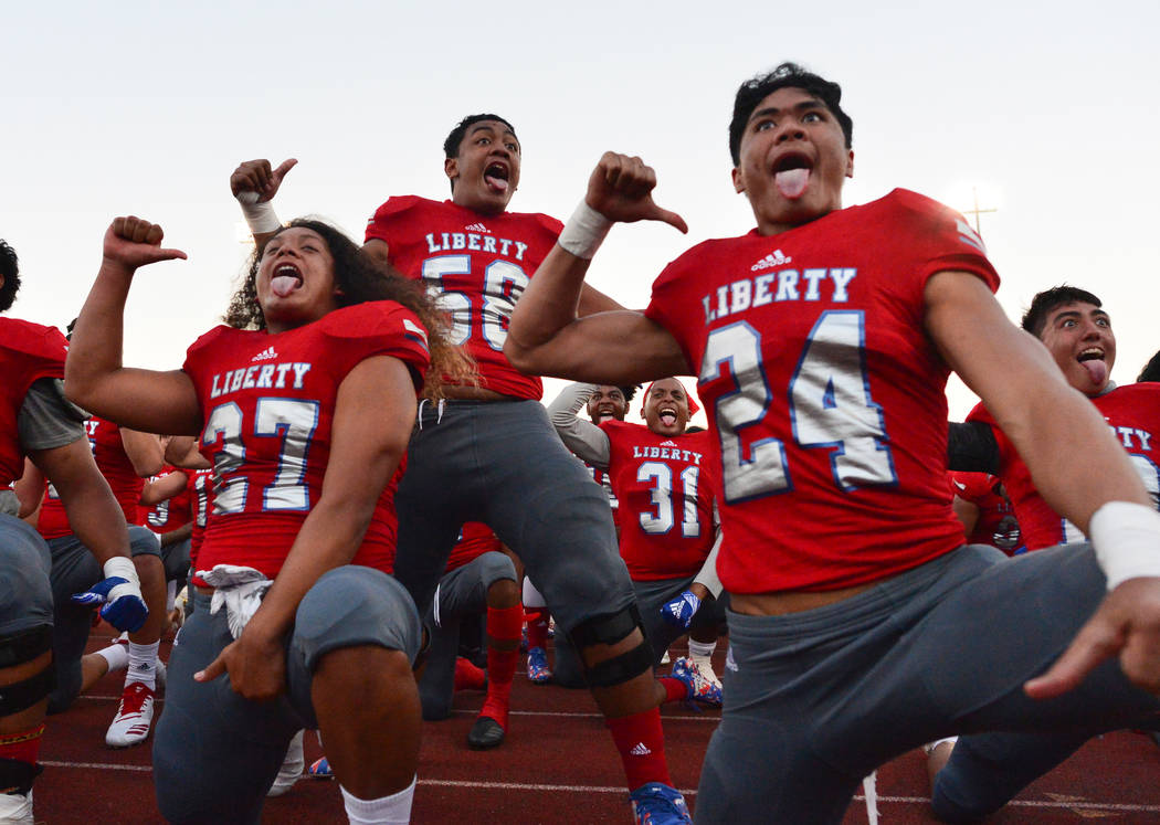 Jared Tufele (27), A.J. Maluia (58) and Lehi Ausage (24), of Liberty High School, perform the Haka before a football game against IMG Academy at Liberty High School in Henderson on Friday, Sept. 7 ...