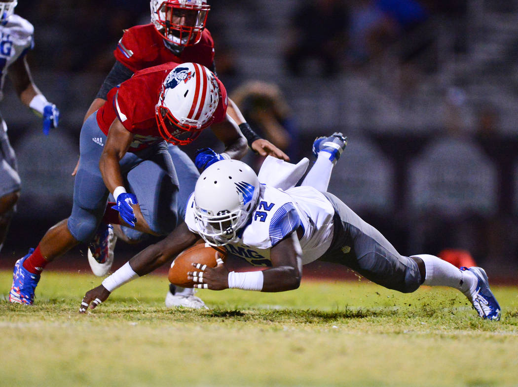 IMG Academy kick returner Chandler Mcgruder (32) recovers a muffed punt under Liberty defensive back Isiah Revis (20) at Liberty High School in Henderson on Friday, Sept. 7, 2018. IMG Academy lead ...