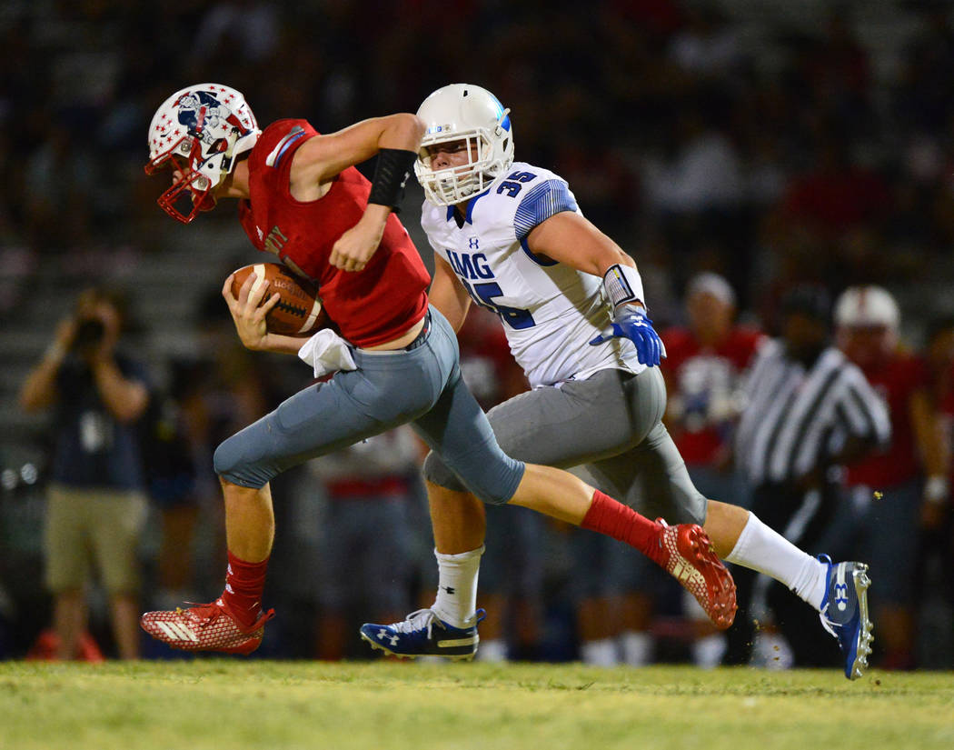 Liberty quarterback Kanyon Stoneking (7) is chased by IMG Academy's Bruce Seton III (35) during a game at Liberty High School in Henderson on Friday, Sept. 7, 2018. IMG Academy won 35-0. Brett Le ...