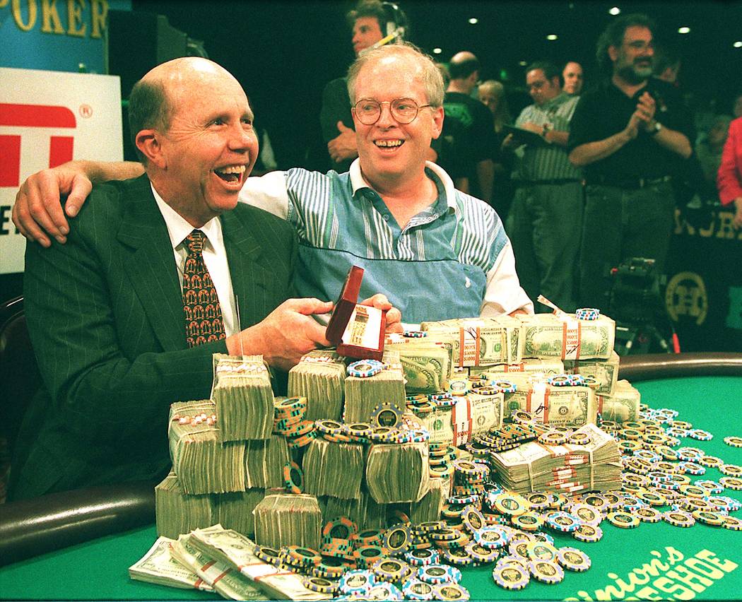 Jack Binion, left, and Dan Harrington of Downey, Calif., look over a mountain of cash and chips on Thursday after Harrington won the 1995 World Series of Poker championship event at Binion's Hors ...