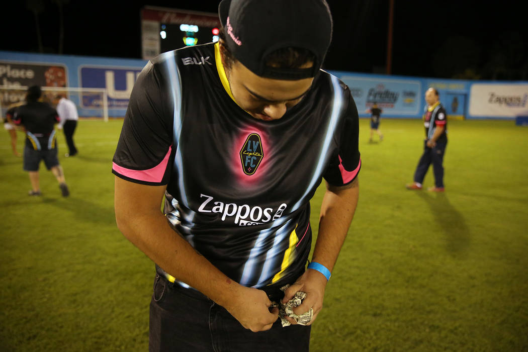 Marck Garcia of Las Vegas shows a piece of the $5,000 he collected from a helicopter cash drop at half time during an USL soccer game between the Las Vegas Lights and LA galaxy II at Cashman Field ...
