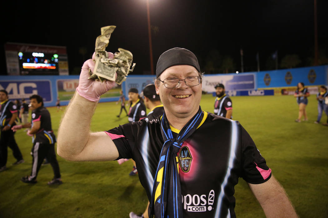 David Weigant of Las Vegas shows a piece of the $5,000 he collected from a helicopter cash drop at half time during an USL soccer game between the Las Vegas Lights and LA galaxy II at Cashman Fiel ...