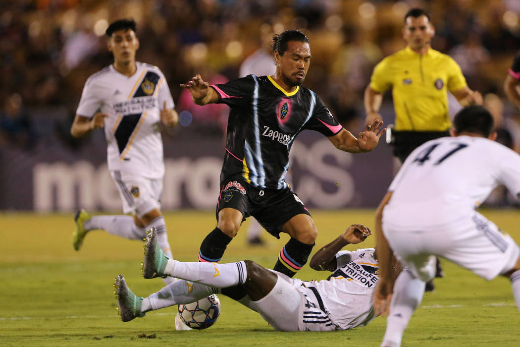 Las Vegas Lights' Daigo Kobayashi (44) loses the ball to a tackled from LA Galaxy II's Geoffrey Acheampong (44) during the first half of an USL game at Cashman Field in Las Vegas, Saturday, Sept. ...