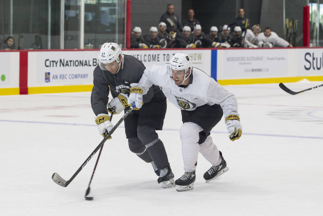 Vegas Golden Knights forward Nick Suzuki, left, (17) and Golden Knights left defenseman Brad Hunt (77) vie for the puck in a scrimmage game during the NHL team's practice at the City National Aren ...