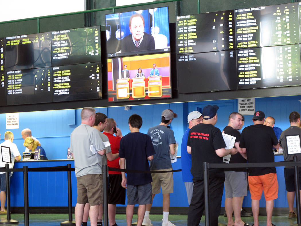 Bettors line up at windows at Monmouth Park racetrack in Oceanport, N.J., to make sports bets. Monmouth Park and Atlantic City's Borgata casino say they're pleased with the extra revenue sports be ...