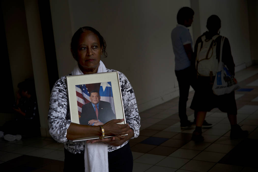 Gloria Rosado Ortiz poses with an image of her late husband, Ernesto Curiel, in San Juan, Puerto Rico, Sept. 4, 2018. Curiel, a 60-year-old who had heart problems and diabetes, walked 10 flights o ...