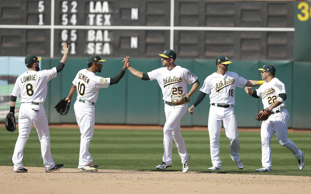 Oakland Athletics' Jed Lowrie, from left, Marcus Semien, Stephen Piscotty, Chad Pinder and Ramon Laureano celebrate after beat the New York Yankees in a baseball game in Oakland, Calif., Monday, S ...