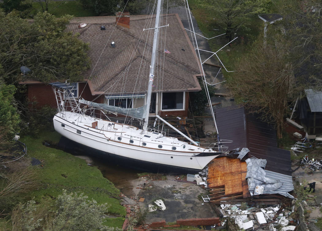 A sailboat is shoved up against a house and a collapsed garage Saturday, Sept. 15, 2018, after heavy wind and rain from Florence, now a tropical storm, blew through New Bern, N.C. (AP Photo/Steve ...